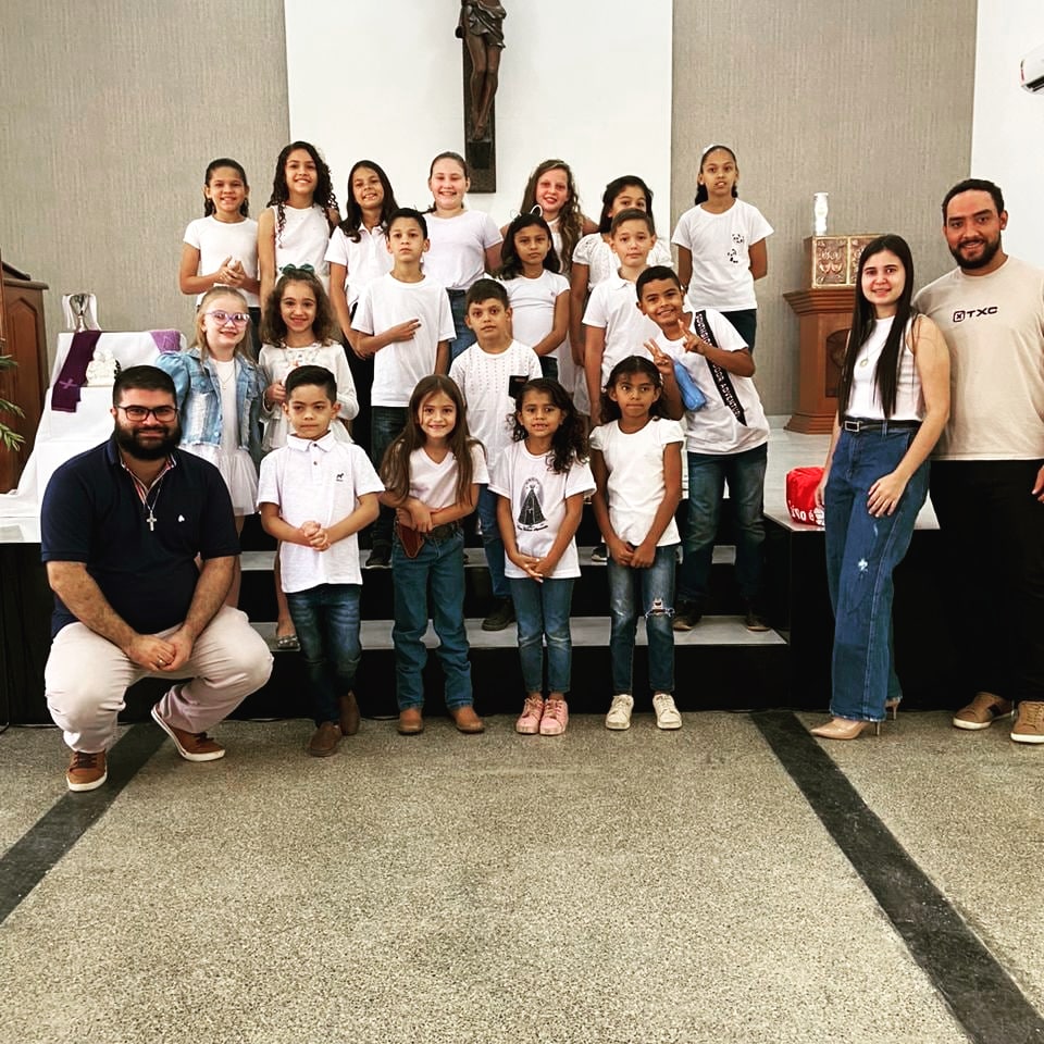 João Vitor, agachado e Paulo e Camila em pé ao lado direito. Ao centro as crianças do Coral Infantil